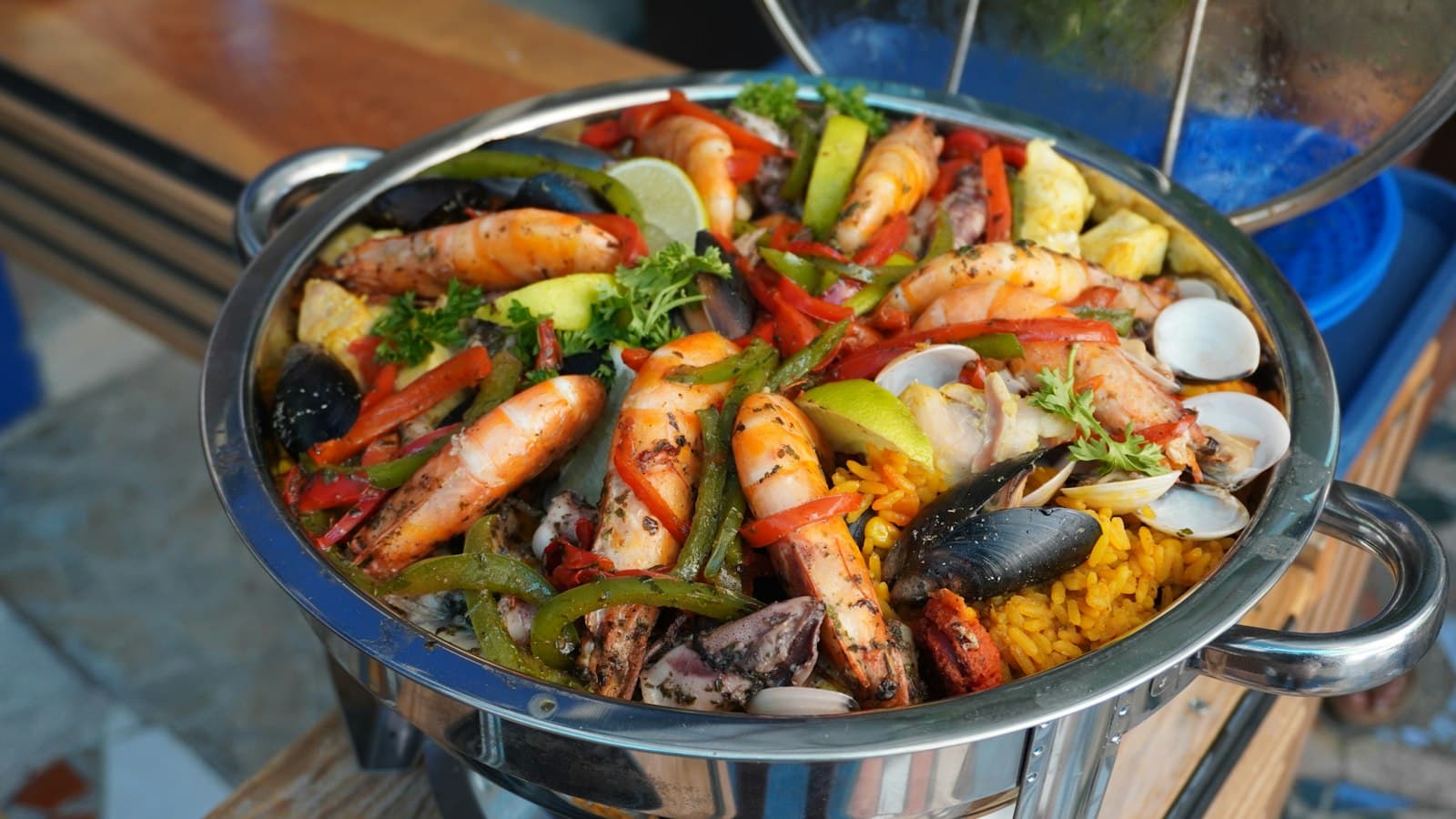 Paellera grande con arroz de marisco, gambas, mejillones y pimientos sobre la mesa